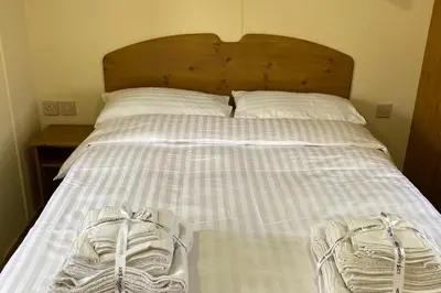 a bed with two shoes sitting on top of it at Caravan - Sleeps 4 - Pet friendly - Parking in Newton Stewart