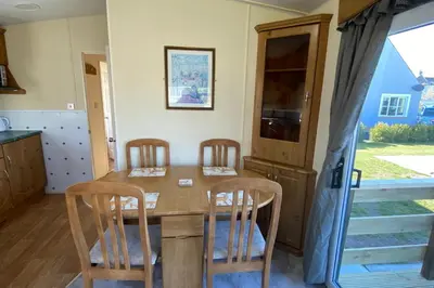 a kitchen with a wooden table and four chairs at Caravan - Sleeps 4 - Pet friendly - Parking in Newton Stewart