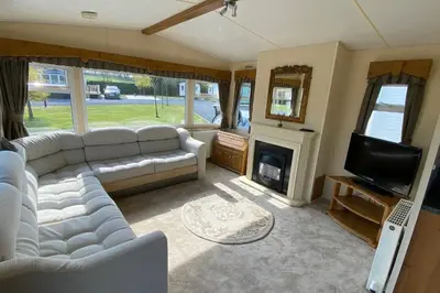 a living room with a couch and a tv and a fireplace at Caravan - Sleeps 4 - Pet friendly - Parking in Newton Stewart