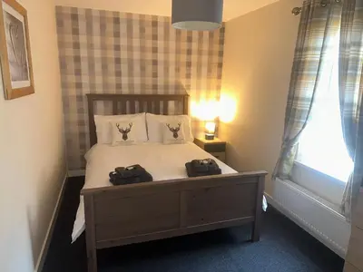 a bedroom with a bed with two bags on it at 3 Dialknowe Holiday Cottage - Wanlockhead - 3 Bedrooms in Wanlockhead