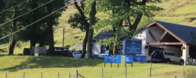 a building with cars parked in a field at 3 Dialknowe Holiday Cottage - Wanlockhead - 3 Bedrooms in Wanlockhead