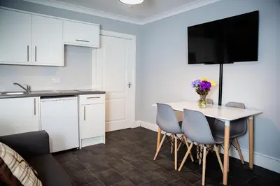 a kitchen and dining room with a table and chairs at St Andrews Guest House in Irvine
