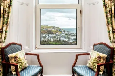 two chairs in front of a window with a view of the ocean at Fernhill Hotel in Portpatrick
