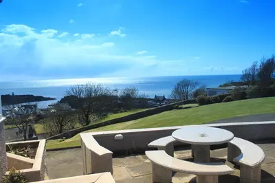 a patio with a table and a view of the ocean at Fernhill Hotel in Portpatrick