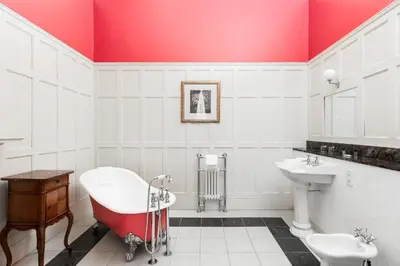 a bathroom with a red ceiling and a tub and sink at Fernhill Hotel in Portpatrick