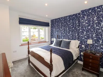 a bedroom with a bed with blue and white wallpaper at The Nook in Keswick
