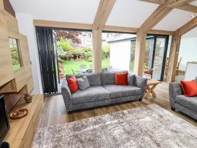 a living room with a gray couch and red pillows at The Nook in Keswick