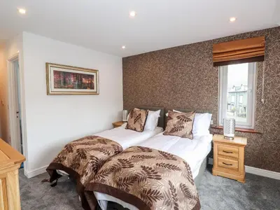 a bedroom with two beds and a window at The Nook in Keswick