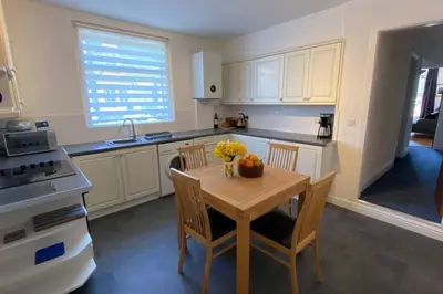 a kitchen with a table and chairs with a bowl of fruit on it at Poet's Corner - flat close to centre of Keswick in Keswick