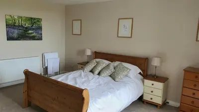 a bedroom with a bed with white sheets and pillows at Dairy Cottage with sea views in Girvan