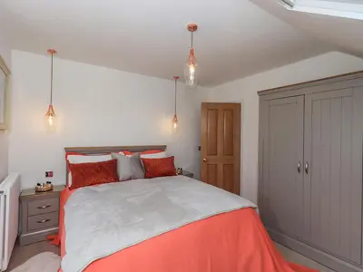 a bedroom with a large bed with red pillows at Seascape in Annan