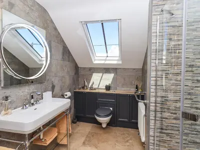 a bathroom with a sink and a toilet and a mirror at Seascape in Annan