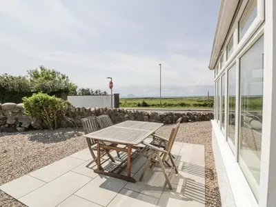 a wooden table and two chairs on a patio at Ailsa Shores in Turnberry
