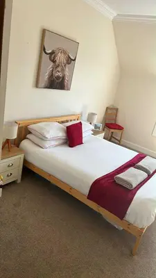 a bedroom with a bed with a picture of a bull at 4 bedroom townhouse Kirkcudbright in Kirkcudbright