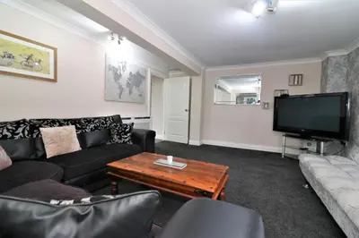a living room with a couch and a tv at Signature - Kirkhill Lower in Kirkmuirhill