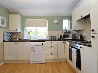 a kitchen with white cabinets and a white refrigerator at 2 Mellfell View in Penrith