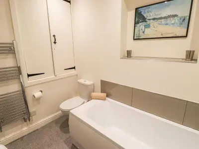 a bathroom with a white tub and a toilet at Two Town End in Penrith