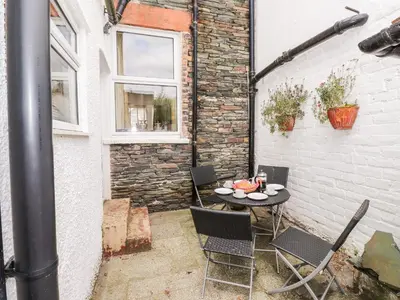 a patio with a table and chairs and a brick wall at Oakhurst in Keswick