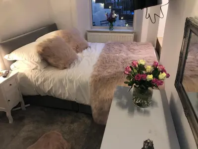 a bedroom with a bed with a vase of flowers on a table at The Coop in Castle Douglas