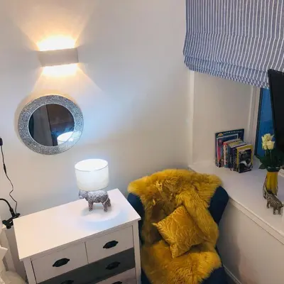 a living room with a chair and a mirror at The Coop in Castle Douglas