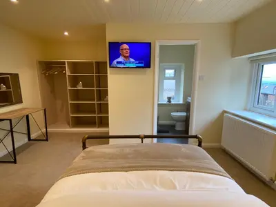 a bedroom with a bed and a television on the wall at Rattlebeck Farm Cottage and Hot Tub PET FRIENDLY in Welton