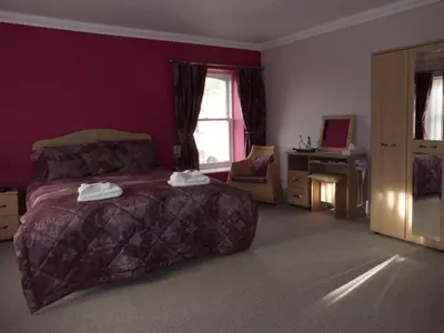 a bedroom with a large bed and a window at The Golden Lion Hotel in Maryport