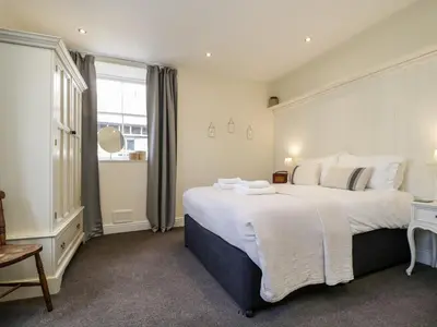 a bedroom with a large white bed and a window at The Bakers Loft in Ambleside