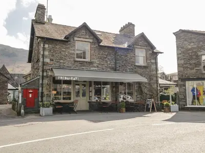 an old stone building on the side of a street at The Bakers Loft in Ambleside