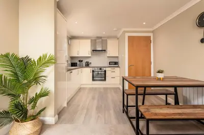 a kitchen and dining room with a table and a plant at Old Prestwick View - Donnini Apartments in Prestwick