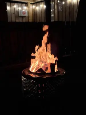 a fire pit in a dark room with flames at Timber Valley Pods in Galston