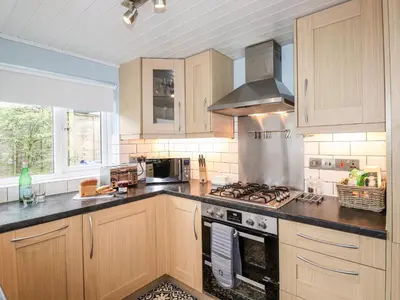 a kitchen with wooden cabinets and a stove top oven at Stanegarth in Keswick
