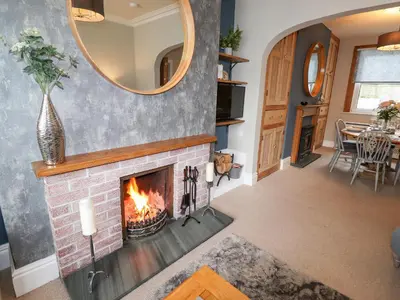 a living room with a fireplace and a mirror at Stanegarth in Keswick