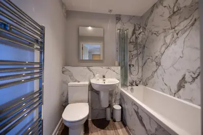 a bathroom with a sink and a toilet and a tub at Troon Executive Apartment in Troon