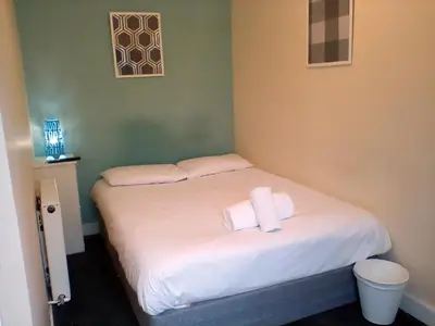 a bedroom with a bed with two towels on it at Irvine Riverside Guesthouse in Irvine