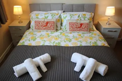 a bed with four white towels on a bed at Carvetii - Uriah House - 4-Bedroom House sleeps up to 10 people in Belle Vue