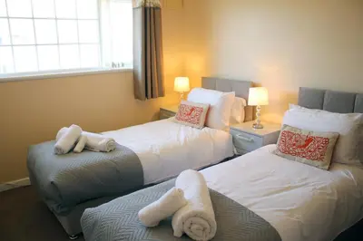 a hotel room with two beds with towels at Carvetii - Uriah House - 4-Bedroom House sleeps up to 10 people in Belle Vue