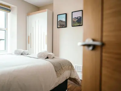 a bedroom with a bed with towels on it at The Deekabout in Keswick