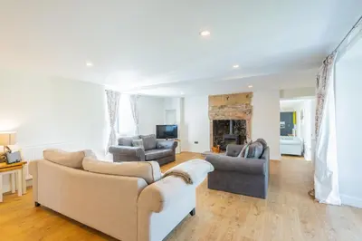 a living room with two couches and a television at Nether Newton - Sleeps 12, Hottub, Sauna, Private Garden in Newmilns