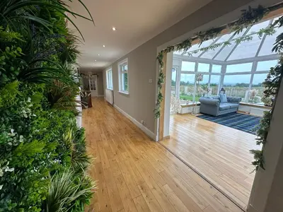 an empty living room with a conservatory with a couch at Alton Villa, Sleeps 12, Great for Families, Undercover Hotub & Games Room in Newmilns