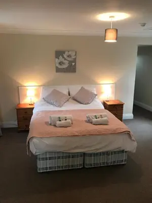 a bedroom with a bed with two pillows on it at The Maxwell Arms Hotel in Dalbeattie