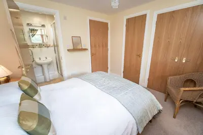 a bedroom with a bed and a sink in it at 11 Howrah's Court in Keswick
