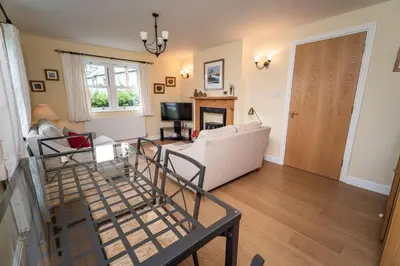a living room with a white couch and a table at 11 Howrah's Court in Keswick