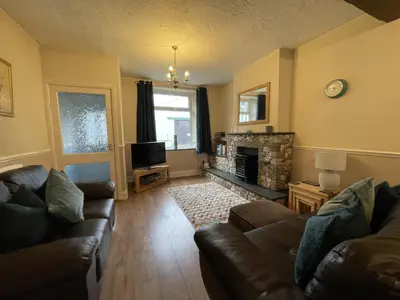 a living room with two couches and a fireplace at Abacourt Cottage in Keswick