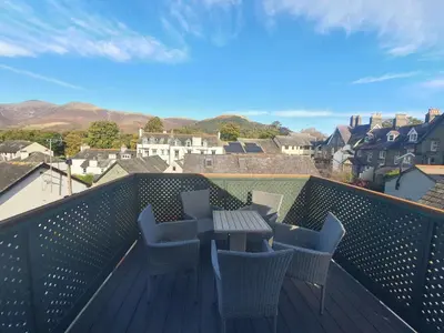 a balcony with a table and chairs on a roof at Abacourt Cottage in Keswick