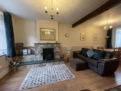 a living room with a couch and a fireplace at Abacourt Cottage in Keswick