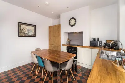 a kitchen with a wooden table and chairs at 3 The Townhouse in Keswick