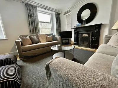 a living room with a couch and a fireplace at 3 The Townhouse in Keswick