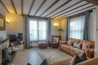 a living room with a couch and a tv at Acorn Cottage in Keswick