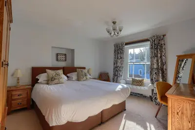 a bedroom with a large bed and a window at Acorn Cottage in Keswick