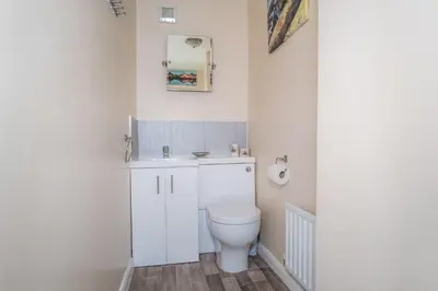 a bathroom with a white toilet and a sink at Acorn Cottage in Keswick